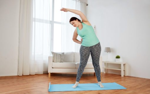 Home - Fit2B.com - smiling plus size woman stretching on mat at home